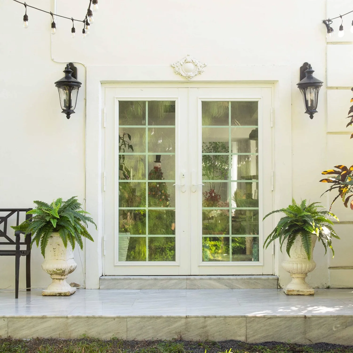 Boston fern silk plants styled on a porch entryway